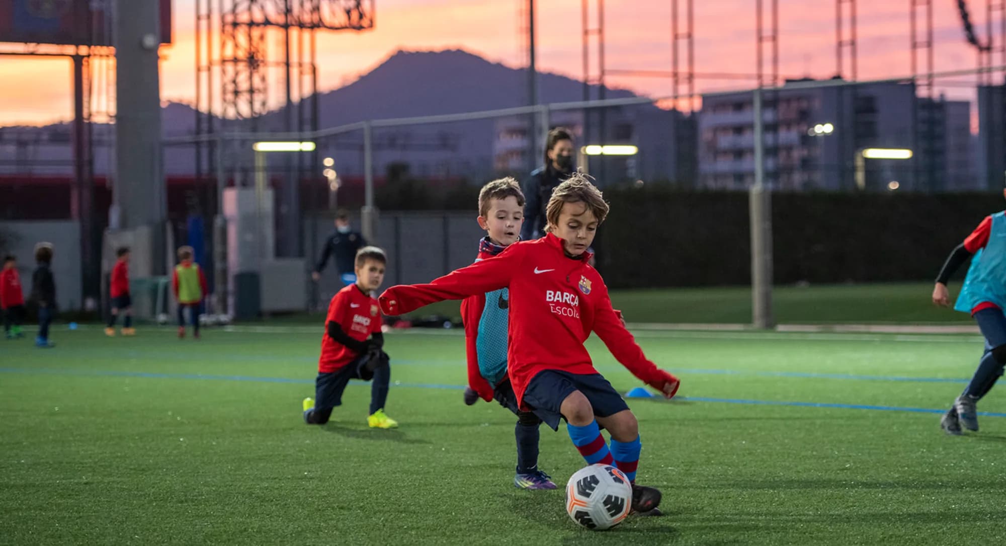 Enfants jouant au football au coucher du soleil